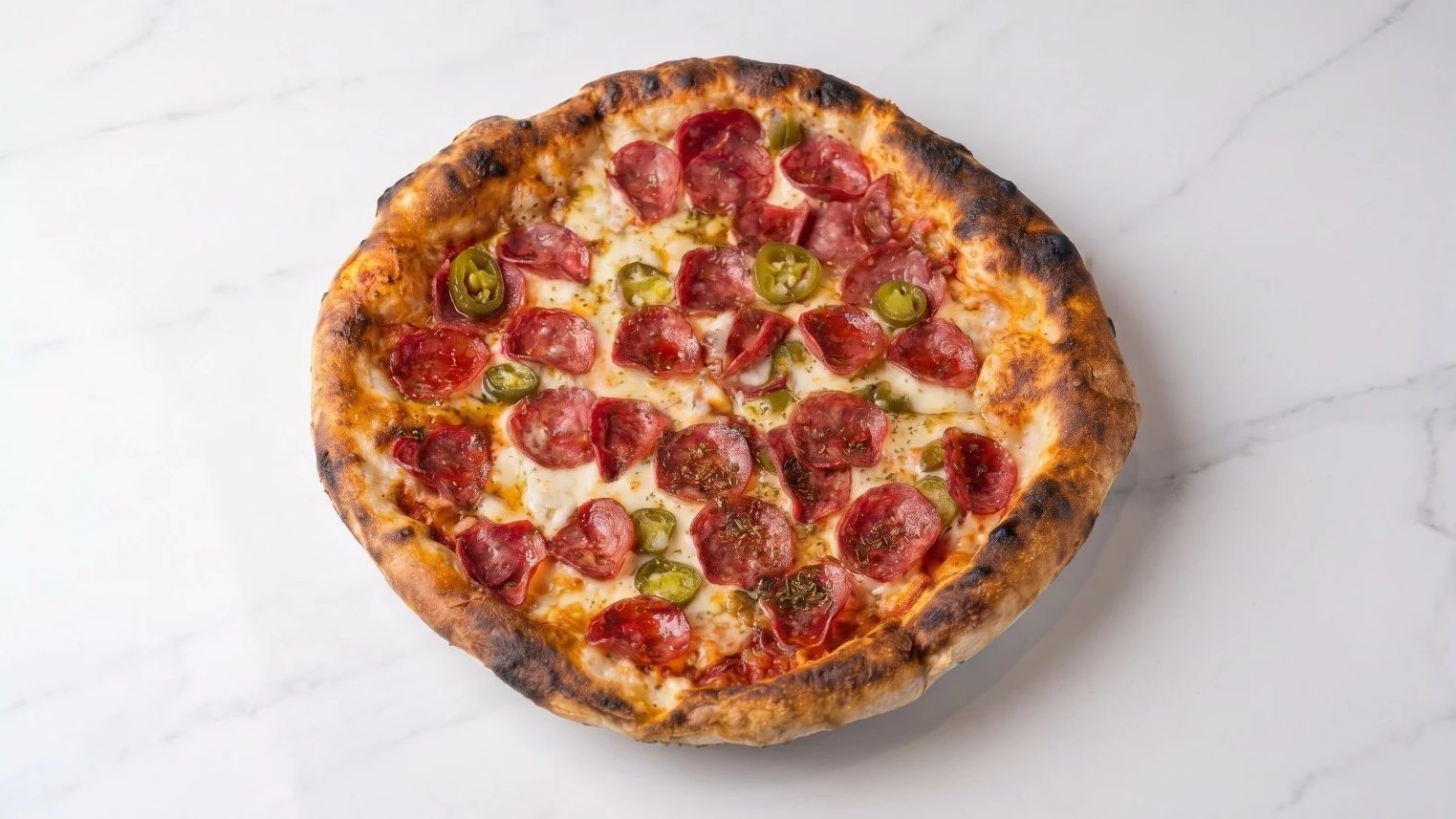A Guilty pizza topped with pepperoni and jalapeños
