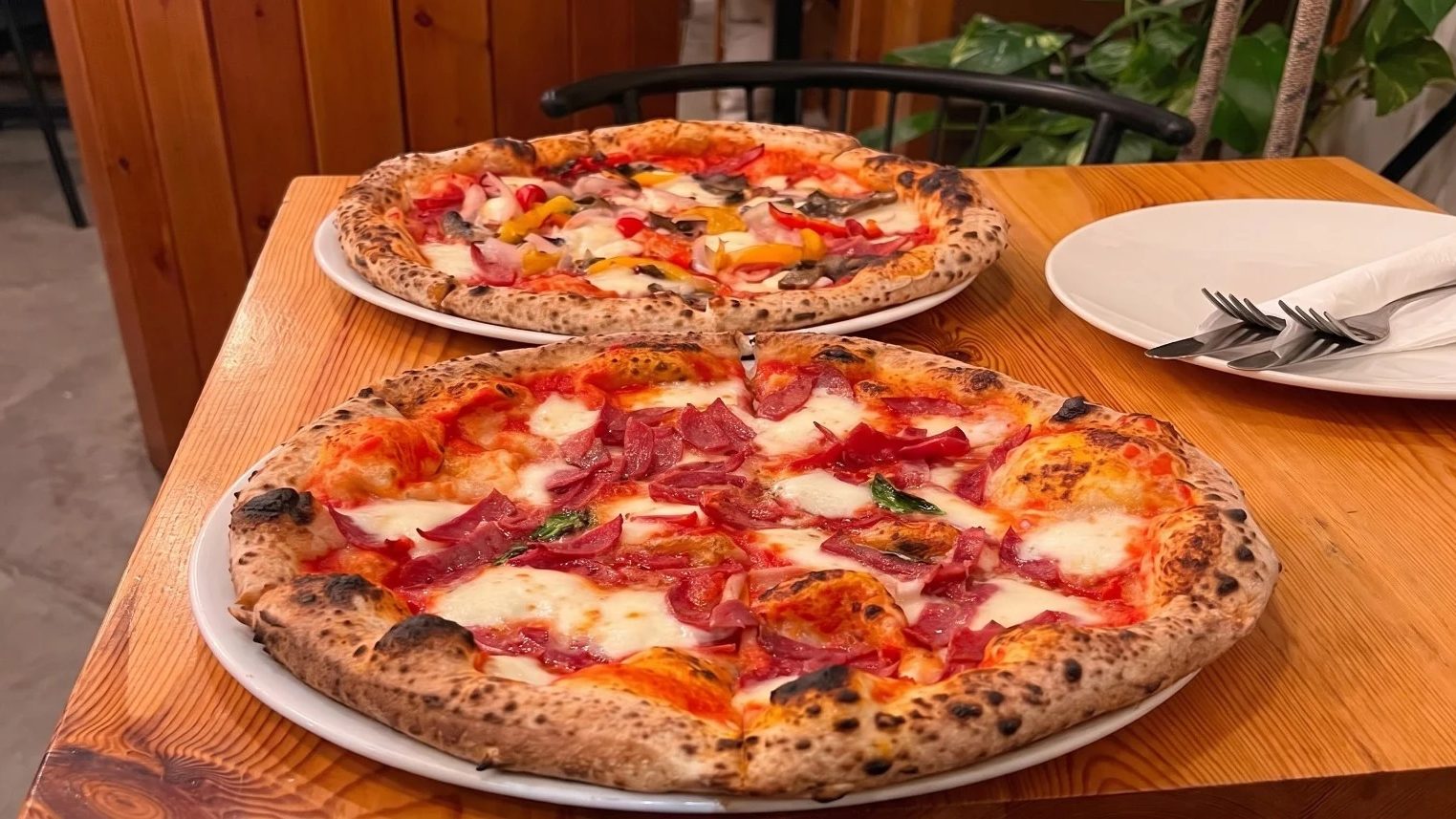 Two What the Crust pizzas served at a restaurant table