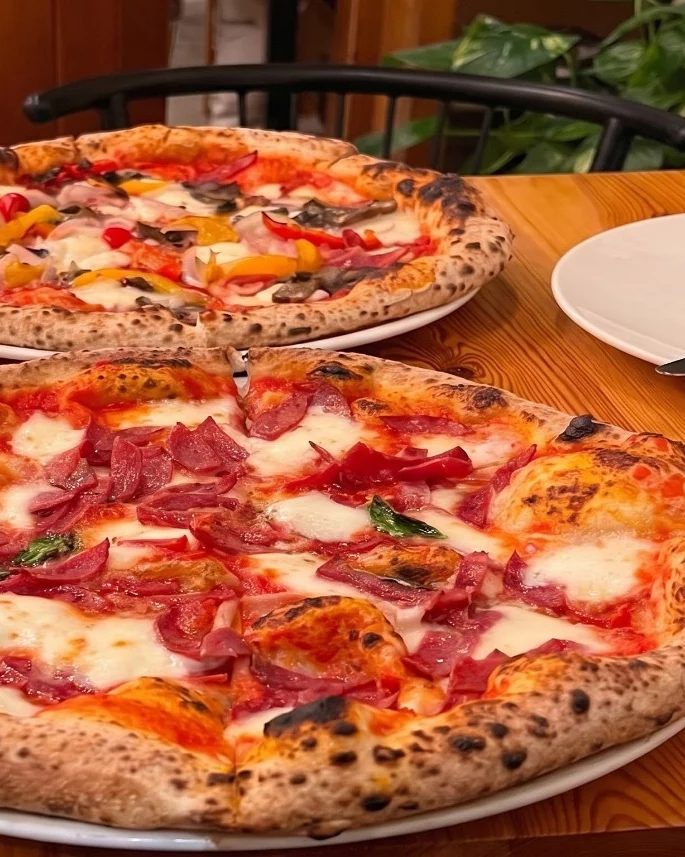 Two What the Crust pizzas served at a restaurant table